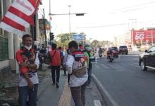 Relawan bagikan 38.250 masker untuk warga yyang dilaksanakan di Perempatan Lembuswana, Samarinda, Kamis (27/8/2026).