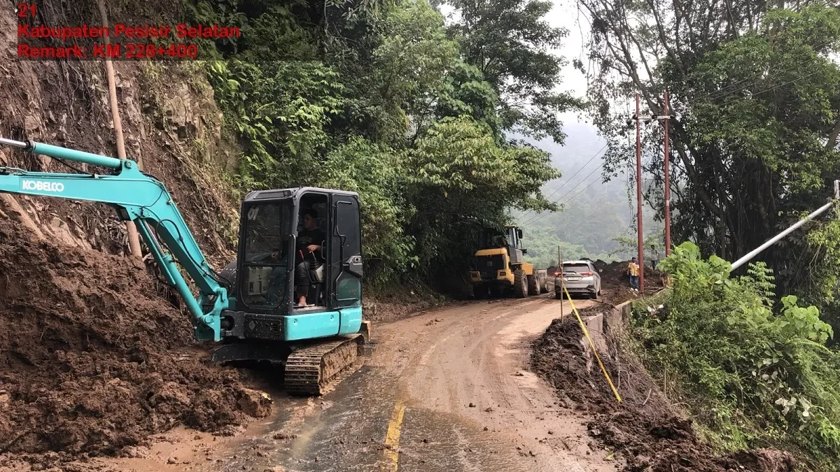 Longsor Tapan Jambi - Alat berat milik Kementerian PU sedang membersihkan material tanah akibat Longsor Tapan Jambi di Kabupaten Pesisir Selatan, Sumatera Barat.